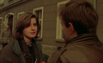 Movie still from “The Double Life of Véronique” (1991), directed by Krzysztof Kieslowski – A man and a woman talking to each other outside; Close Up shot, Over the shoulder angle