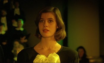 Movie still from “The Double Life of Véronique” (1991), directed by Krzysztof Kieslowski – A woman with short brown hair wearing a black sweater; Close Up shot, Over the shoulder angle