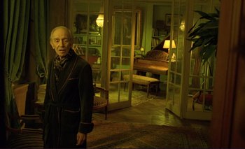 Movie still from “The Double Life of Véronique” (1991), directed by Krzysztof Kieslowski – An old man standing in front of an open door in a living room; Medium shot, High angle