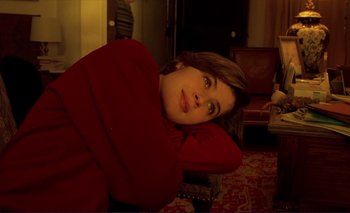 Movie still from “The Double Life of Véronique” (1991), directed by Krzysztof Kieslowski – A woman in a red shirt is laying on a chair; Close Up shot, High angle