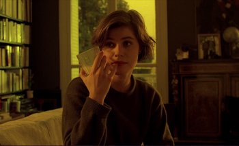 Movie still from “The Double Life of Véronique” (1991), directed by Krzysztof Kieslowski – A person holding a cell phone up to their ear; Close Up shot, High angle