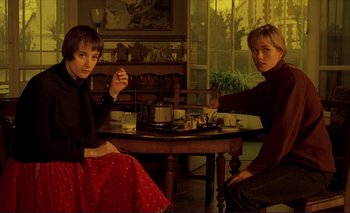 Movie still from “The Double Life of Véronique” (1991), directed by Krzysztof Kieslowski – Two people sitting at a table with a cup of tea; Medium shot, High angle