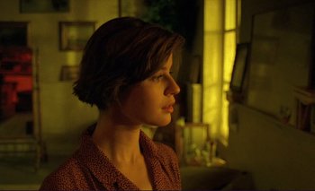 Movie still from “The Double Life of Véronique” (1991), directed by Krzysztof Kieslowski – A woman with short brown hair looking into the distance; Close Up shot, Over the shoulder angle