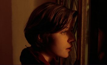 Movie still from “The Double Life of Véronique” (1991), directed by Krzysztof Kieslowski – A young boy looking out a window at night; Close Up shot, Over the shoulder angle