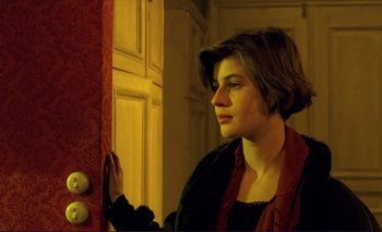 Movie still from “The Double Life of Véronique” (1991), directed by Krzysztof Kieslowski – A woman standing in front of a red door; Close Up shot, Over the shoulder angle