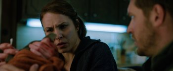 Movie still from “The Drop” (2014), directed by Michaël R. Roskam – A person in a room near a window; Close Up shot, Over the shoulder angle