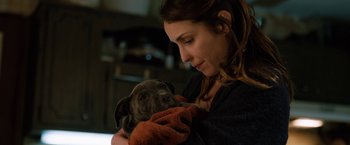 Movie still from “The Drop” (2014), directed by Michaël R. Roskam – A woman is holding a dog in her arms; Close Up shot, High angle