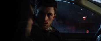 Movie still from “The Drop” (2014), directed by Michaël R. Roskam – A person sitting in a car; Close Up shot, Over the shoulder angle