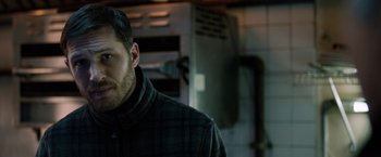 Movie still from “The Drop” (2014), directed by Michaël R. Roskam – A person wearing a jacket in a room; Close Up shot, Over the shoulder angle