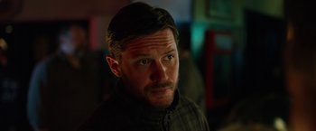 Movie still from “The Drop” (2014), directed by Michaël R. Roskam – A person wearing a black jacket; Close Up shot, Over the shoulder angle