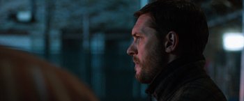 Movie still from “The Drop” (2014), directed by Michaël R. Roskam – A person looking to the side; Close Up shot, Over the shoulder angle