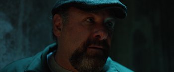 Movie still from “The Drop” (2014), directed by Michaël R. Roskam – A person with a beard wearing a hat; Close Up shot, Low angle