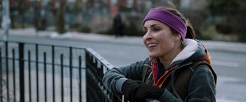 Movie still from “The Drop” (2014), directed by Michaël R. Roskam – A woman wearing a purple head band is smiling; Close Up shot, Over the shoulder angle