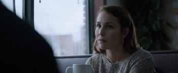 Movie still from “The Drop” (2014), directed by Michaël R. Roskam – A woman sitting in front of a window holding a mug; Close Up shot, Over the shoulder angle