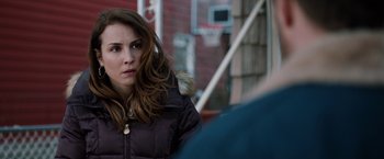 Movie still from “The Drop” (2014), directed by Michaël R. Roskam – A woman in a black jacket is looking at the camera; Close Up shot, Over the shoulder angle