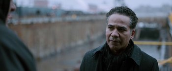 Movie still from “The Drop” (2014), directed by Michaël R. Roskam – A person wearing a black jacket; Close Up shot, Over the shoulder angle