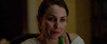 Movie still from “The Drop” (2014), directed by Michaël R. Roskam – A person holding a green object; Close Up shot, Over the shoulder angle