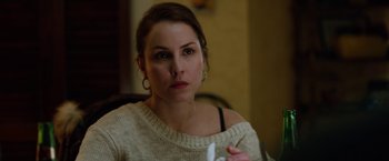 Movie still from “The Drop” (2014), directed by Michaël R. Roskam – A woman holding a remote control in her hand; Close Up shot, Over the shoulder angle