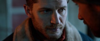 Movie still from “The Drop” (2014), directed by Michaël R. Roskam – A man with a beard and mustache; Close Up shot, Over the shoulder angle