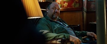 Movie still from “The Drop” (2014), directed by Michaël R. Roskam – A person sitting in a chair; Medium shot, Over the shoulder angle