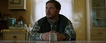 Movie still from “The Drop” (2014), directed by Michaël R. Roskam – A person sitting at a table; Close Up shot, High angle