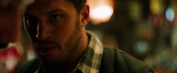 Movie still from “The Drop” (2014), directed by Michaël R. Roskam – A man's face with a blurry background; Close Up shot, Over the shoulder angle