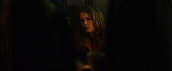Movie still from “The Drop” (2014), directed by Michaël R. Roskam – A woman is looking into a mirror in a dark room; Close Up shot, Over the shoulder angle