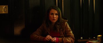 Movie still from “The Drop” (2014), directed by Michaël R. Roskam – A woman sitting in front of a wooden wall; Close Up shot, Low angle