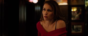 Movie still from “The Drop” (2014), directed by Michaël R. Roskam – A woman in a red sweater is looking into the distance; Close Up shot, Over the shoulder angle
