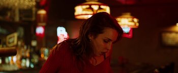 Movie still from “The Drop” (2014), directed by Michaël R. Roskam – A woman in a red sweater is looking down; Close Up shot, Low angle