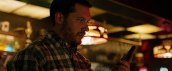 Movie still from “The Drop” (2014), directed by Michaël R. Roskam – A person using a cell phone; Close Up shot, Low angle