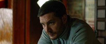 Movie still from “The Drop” (2014), directed by Michaël R. Roskam – A person wearing a shirt; Close Up shot, High angle