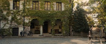 Movie still from “The Duke of Burgundy” (2014), directed by Peter Strickland – A bicycle parked in front of a building covered in ivy; Extreme Wide shot, Low angle