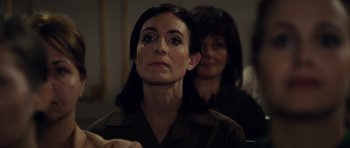 Movie still from “The Duke of Burgundy” (2014), directed by Peter Strickland – A woman is looking at the camera while another woman looks on; Close Up shot, Over the shoulder angle