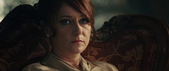 Movie still from “The Duke of Burgundy” (2014), directed by Peter Strickland – A person sitting in a chair; Close Up shot, Over the shoulder angle