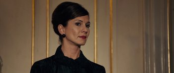 Movie still from “The Duke of Burgundy” (2014), directed by Peter Strickland – A person wearing a black shirt; Close Up shot, Over the shoulder angle