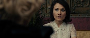 Movie still from “The Duke of Burgundy” (2014), directed by Peter Strickland – A woman in a white blouse is looking at a camera; Close Up shot, Over the shoulder angle