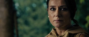 Movie still from “The Duke of Burgundy” (2014), directed by Peter Strickland – A woman's face in front of trees; Close Up shot, Over the shoulder angle