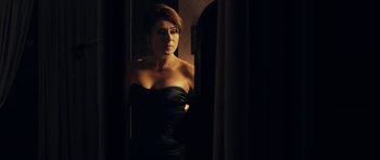 Movie still from “The Duke of Burgundy” (2014), directed by Peter Strickland – A woman in a black dress looking into a mirror; Medium shot, Over the shoulder angle