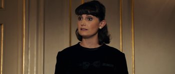 Movie still from “The Duke of Burgundy” (2014), directed by Peter Strickland – A woman in a black shirt with a bow in her hair; Close Up shot, Over the shoulder angle