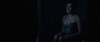 Movie still from “The Duke of Burgundy” (2014), directed by Peter Strickland – A woman sitting in the dark wearing lingerie; Medium shot, High angle
