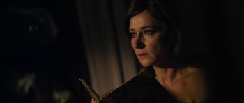 Movie still from “The Duke of Burgundy” (2014), directed by Peter Strickland – A woman holding a book in her hands; Close Up shot, Over the shoulder angle