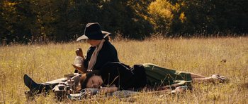Movie still from “The Duke of Burgundy” (2014), directed by Peter Strickland – Two women laying in the grass on a picnic blanket; Medium shot, High angle