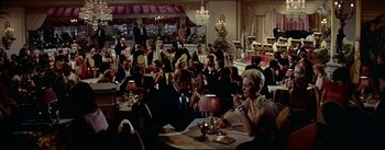 Movie still from “The Eddy Duchin Story” (1956), directed by George Sidney – A group of people sitting at a table in a restaurant; Extreme Wide shot, High angle