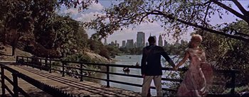 Movie still from “The Eddy Duchin Story” (1956), directed by George Sidney – A man standing on a bridge looking at a river; Extreme Wide shot, High angle