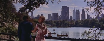 Movie still from “The Eddy Duchin Story” (1956), directed by George Sidney – A woman standing on a pier near a body of water; Wide shot, High angle