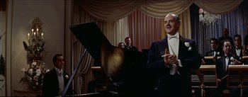 Movie still from “The Eddy Duchin Story” (1956), directed by George Sidney – An older man sitting in front of a piano; Medium shot, Low angle