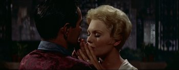 Movie still from “The Eddy Duchin Story” (1956), directed by George Sidney – A man and a woman are kissing in a room; Close Up shot, High angle