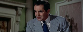 Movie still from “The Eddy Duchin Story” (1956), directed by George Sidney – A man in a suit and tie looking at the camera; Close Up shot, Over the shoulder angle