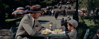 Movie still from “The Eddy Duchin Story” (1956), directed by George Sidney – A man sitting at a table with a plate of food; Medium shot, High angle